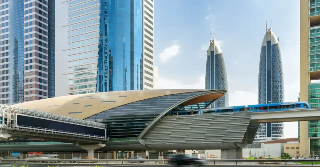 Dubai metro station with futuristic architecture and metro train passing through, surrounded by skyscrapers